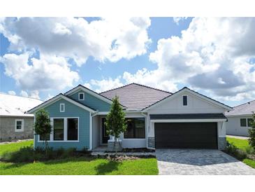 Charming one-story home features a two-car garage, paver driveway, and well-manicured lawn at 18051 Foxtail Loop, Venice, FL 34293