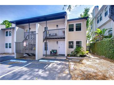 Two-story condo building with parking area and exterior stairs and balcony on a sunny day at 527 S Lincoln Ave # A108, Tampa, FL 33609