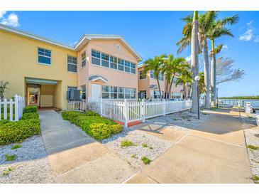 Charming condo building with a white picket fence and walkway leading to the front door and waterfront view at 19417 Gulf Blvd # B-210, Indian Shores, FL 33785