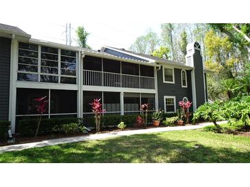 Charming condo featuring a screened lanai, upper balcony, manicured landscaping and neutral paint scheme at 2101 Fox Chase Blvd # 102, Palm Harbor, FL 34683