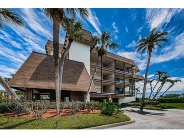 Three-story condo building has a brown roof, carports and palm trees at 3021 Countryside Blvd # 24A, Clearwater, FL 33761