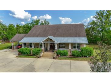 Inviting single-story home with a covered porch and meticulously maintained landscaping at 6448 Country Club Rd, Wesley Chapel, FL 33544