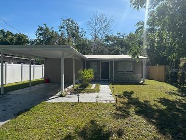 Charming single-story home featuring a carport, walkway lights, and a well-maintained front lawn at 7106 S Sparkman St, Tampa, FL 33616