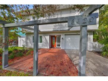 Inviting home with a covered entrance, brick patio, attached garage, and prominent house number at 8420 Orient Ne Way, St Petersburg, FL 33702