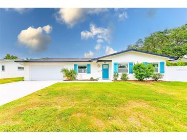 Charming one story home with colorful shutters, landscaped yard, and a white exterior at 1851 Glenville Dr, Clearwater, FL 33765