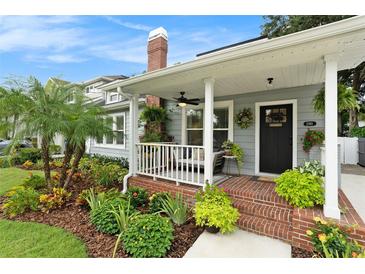 Charming home featuring a brick front porch and beautifully landscaped yard with vibrant plants and a welcoming entrance at 2910 W Aquilla St, Tampa, FL 33629