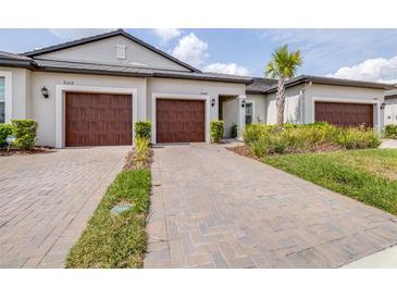 Charming home showcasing a neatly paved driveway leading to its two-car garage and freshly manicured lawn at 31408 Cabana Rye Ave, San Antonio, FL 33576