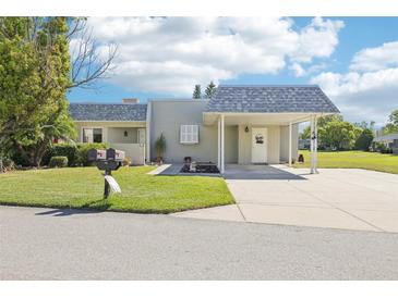 Charming single-story home featuring a covered carport and meticulously maintained front yard landscaping at 3252 Scorecard Dr, New Port Richey, FL 34655