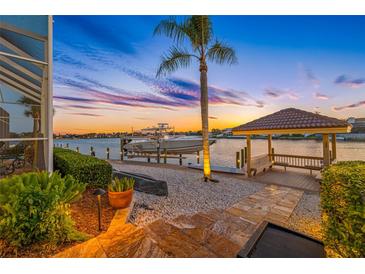 Beautiful waterfront view featuring a private dock, boat lift, and charming gazebo perfect for relaxation and enjoying the sunset at 5812 Mariners Watch Dr, Tampa, FL 33615