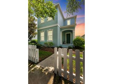 Charming two-story home featuring a picket fence, inviting entrance and lush landscaping at 6111 Hadley Commons Dr, Riverview, FL 33578