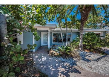 Charming single-story home with mature landscaping and a brick walkway leading to the front door at 810 Lantana Ave, Clearwater Beach, FL 33767
