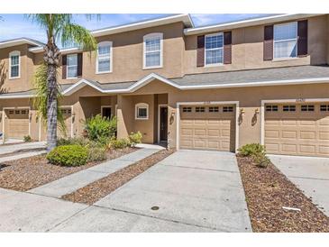 Charming townhouse with an attached garage, well-manicured lawn, and lovely front yard landscaping at 10418 Tulip Field Way, Riverview, FL 33578