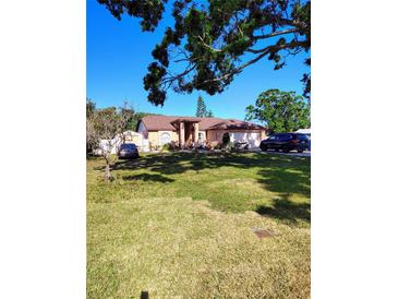 Charming one-story home with a well-manicured front lawn, lovely landscaping, and a two-car garage at 1061 6Th Nw St, Largo, FL 33770