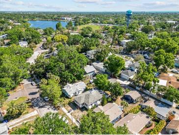 Aerial view of a quiet neighborhood with lush trees, a community lake, and a grassy field at 1115 Crescent Lake N Dr, St Petersburg, FL 33701