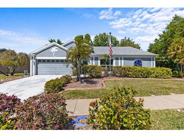 Charming home with mature landscaping, palm trees, and well-manicured lawn at 1700 Hunter Ln, Tarpon Springs, FL 34689