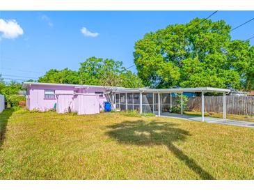 Backyard featuring a covered parking area, screened lanai, and lush landscaping at 2827 1St Ne St, St Petersburg, FL 33704