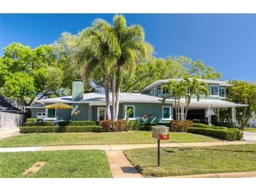 Charming home with mature landscaping and a spacious covered carport nestled among mature trees at 126 Orangewood Dr, Dunedin, FL 34698
