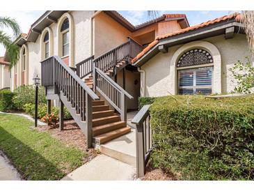 Charming condo featuring a private entrance with staircase, complemented by well-maintained landscaping and architectural design at 2636 Enterprise E Rd # C24, Clearwater, FL 33759
