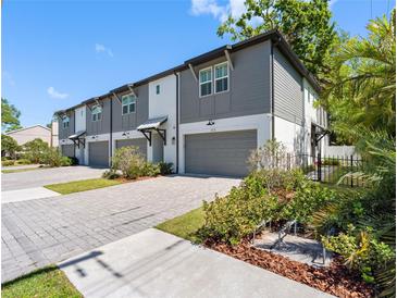 Newly constructed townhomes featuring gray and white exterior, private garages, and paver driveways at 410 S Church Ave, Tampa, FL 33609