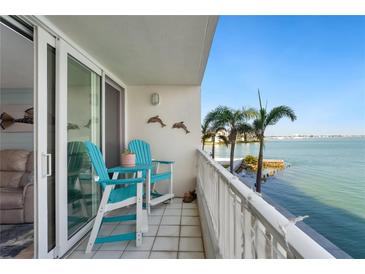 Relaxing balcony featuring blue chairs, palm trees, and a beautiful waterfront view at 5279 Isla Key S Blvd # 212, St Petersburg, FL 33715
