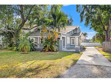 Charming historic home with manicured lawn, tropical landscaping, and inviting front porch at 103 S Habana Ave, Tampa, FL 33609