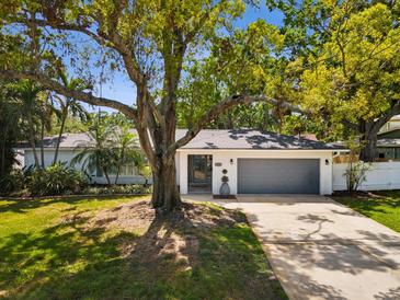 Charming single-story home featuring a brick exterior, mature trees and a well-manicured lawn at 1666 N Dakota Ne Ave, St Petersburg, FL 33703