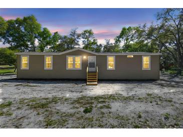 Charming tan single-story home with wood steps leading to the front door at 17913 Greensboro St, Spring Hill, FL 34610