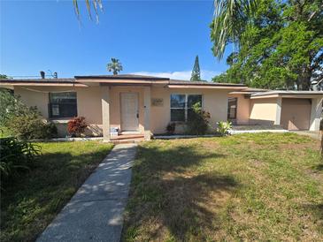 Charming single-story home featuring a well-maintained lawn, mature trees, and inviting front entrance at 204 Shore W Dr, Oldsmar, FL 34677