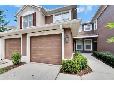 Charming townhome featuring a well-maintained exterior, a one-car garage, and beautiful landscaping at 2119 Kings Palace Dr, Riverview, FL 33578