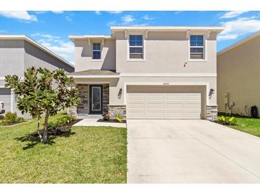 Charming two-story home with a well-maintained lawn, stone accents, and attached two-car garage at 36541 Night Strawberry Ct, Dade City, FL 33525