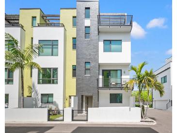 Modern townhome with a black brick accent, balconies, gated entry, and well maintained landscaping at 907 Arlington N Ave, St Petersburg, FL 33705