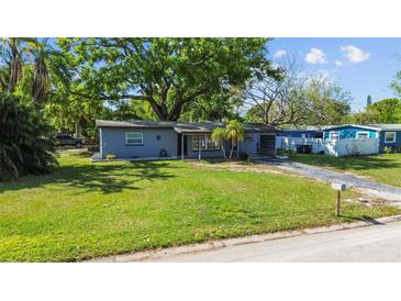 Charming single-story home featuring a well-maintained lawn and mature trees providing ample shade at 1411 Barry St, Clearwater, FL 33756