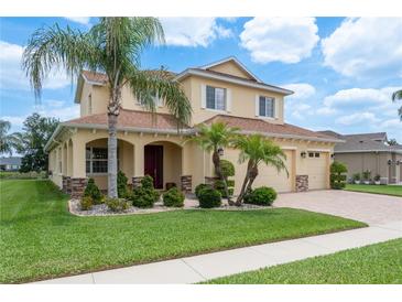 Charming two-story home boasts a well-manicured lawn, complemented by lush landscaping and a three-car garage at 19123 Sunset Bay Dr, Land O Lakes, FL 34638