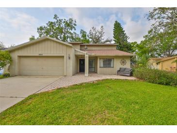 Charming single-Gathering home featuring a well-manicured lawn and an attached two-car garage at 2812 Ormandy Ct, Tampa, FL 33618