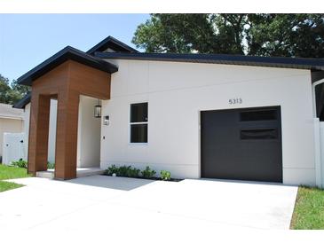 Contemporary home boasts a sleek garage door, modern lighting and a minimalist, landscaped yard at 5518 Newton S Ave, Gulfport, FL 33707