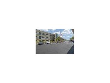 Well-maintained building with ample parking, trees, and an American flag flying in the breeze at 5990 Terrace Park N Dr # 109, St Petersburg, FL 33709