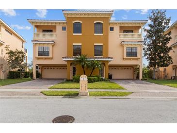 Beautiful multi-level townhome with a two-car garage, manicured landscaping, and private balcony at 1537 Ember Ln, Tarpon Springs, FL 34689