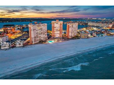 Stunning aerial view of beachfront condo towers with city skyline and ocean sunset backdrop at 17920 Gulf Blvd # 2004, Redington Shores, FL 33708