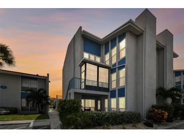 Beautiful 3-story condo building with blue trim and lots of large windows at dusk at 315 Medallion Blvd # E, Madeira Beach, FL 33708