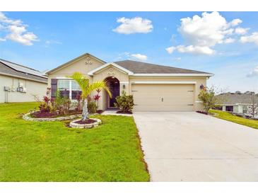 Charming one-story home featuring a manicured lawn and a two car garage at 6882 Silverado Ranch Blvd, Zephyrhills, FL 33541