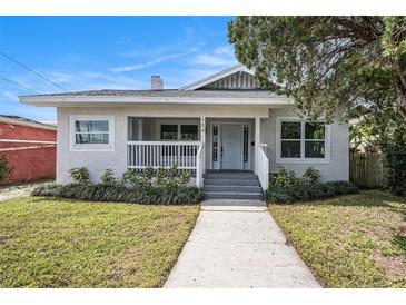 Charming single-story home featuring a welcoming front porch and well-manicured lawn at 104 W South Ave, Tampa, FL 33603