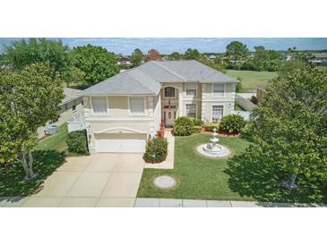 Beautiful two-story home features a well-manicured lawn with mature trees and a charming water fountain feature at 13122 Prestwick Dr, Riverview, FL 33579