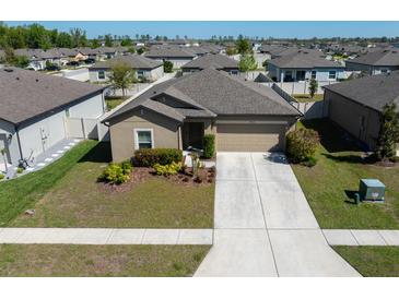 Charming single-story home with a two-car garage, well-manicured lawn, and beautiful landscaping at 18715 Alfaro Loop Ct, Spring Hill, FL 34610