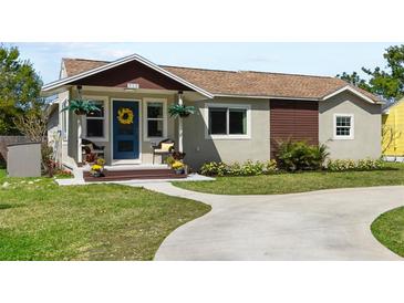 Charming single Gathering home with a blue door, covered porch and an inviting landscaped yard at 715 39Th Ne Ave, St Petersburg, FL 33703