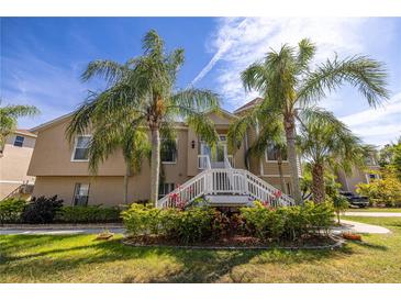 Two-story home featuring a well-manicured lawn and decorative palm trees at 7345 Brightwaters Ct, New Port Richey, FL 34652