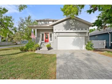 Charming home featuring well-manicured lawn, paved driveway, and inviting red front door at 7417 S Morton St, Tampa, FL 33616