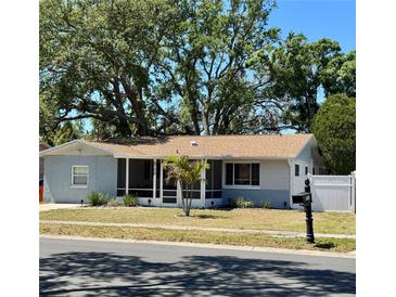 Charming single-story home featuring a screened porch and well-maintained front yard at 8766 91St St, Seminole, FL 33777