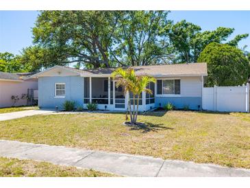 Charming single-story home with a well-maintained lawn, palm tree, and screened front porch at 8766 91St St, Seminole, FL 33777