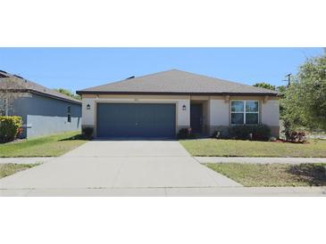 Charming single-story home featuring a well-manicured lawn, neutral paint, and a convenient two-car garage at 901 Golden Shiner Ave, Ruskin, FL 33570