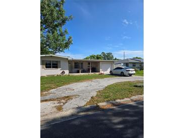 Charming single-story home with a covered porch, driveway, and well-manicured lawn at 1448 Lemon St, Clearwater, FL 33756